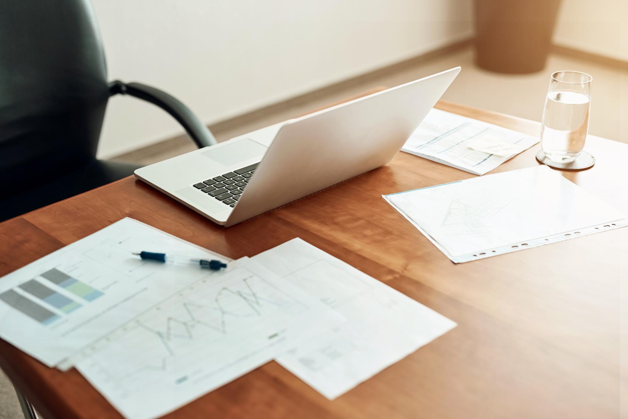 Modern workspace with documents and laptop